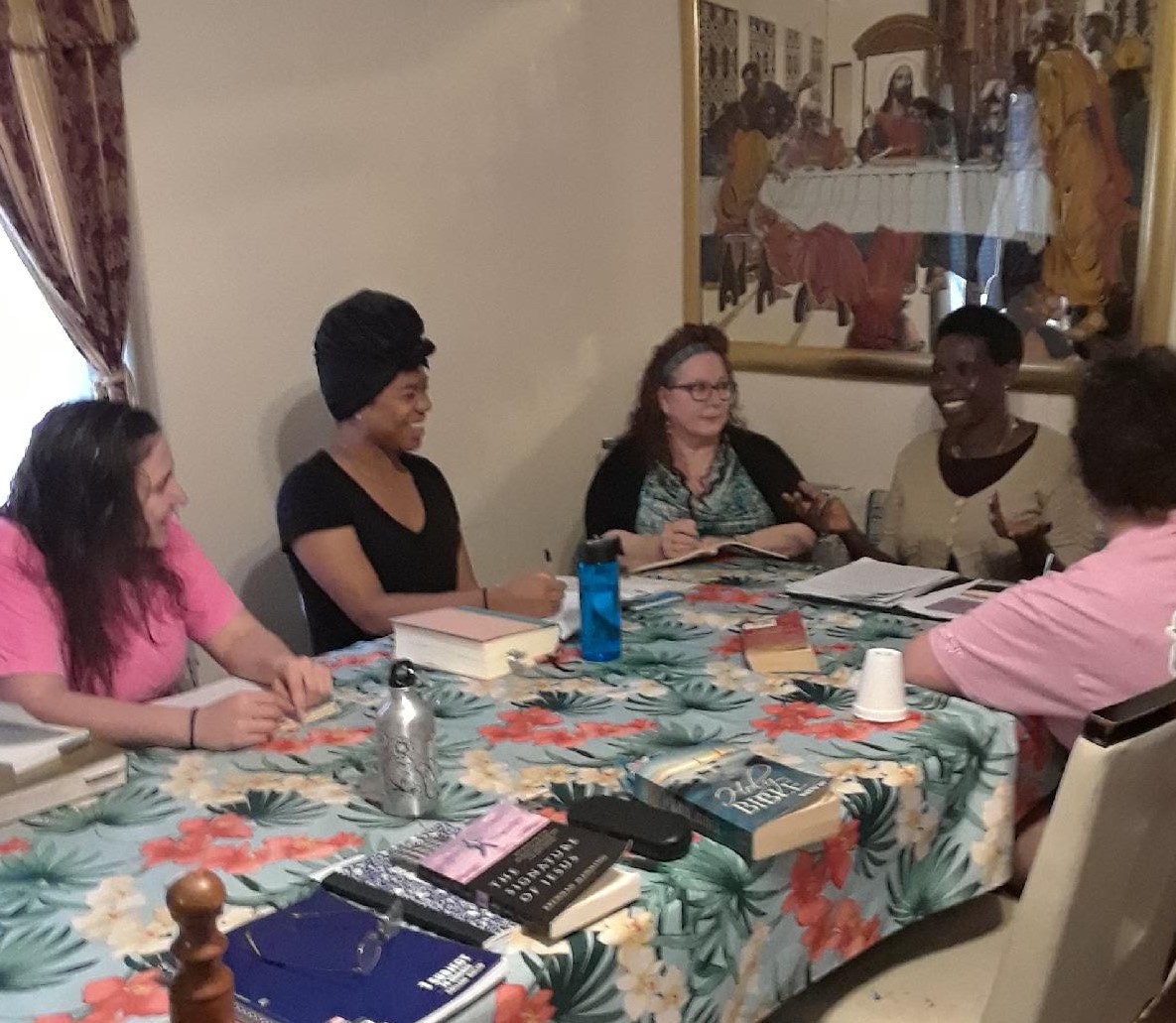 Five women sitting together around a table.