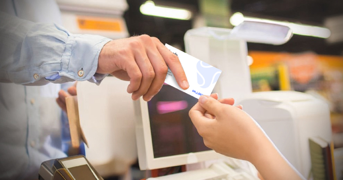 Hands exchanging business card in office.