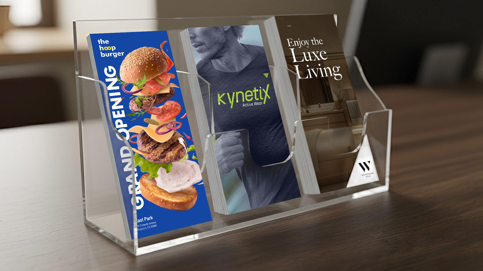Three different promotional rack cards arranged in a clear acrylic countertop display stand.